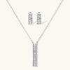 White gold plated necklace with vertical cubic zirconia pendant and matching hoop earrings on neutral background