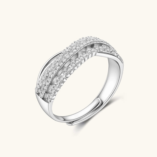 Sterling silver crossover ring with pavΓ©-set moissanite stones creating an elegant infinity design on neutral background
