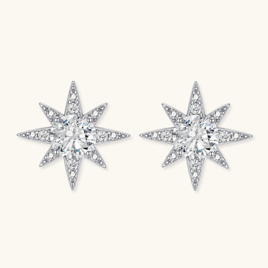 Sterling silver star-shaped stud earrings with brilliant moissanite center stones and pavΓ© details on neutral background.