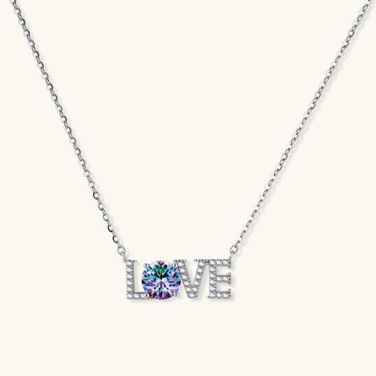 Sterling silver LOVE necklace with brilliant moissanite center stone and pavé details on neutral background.