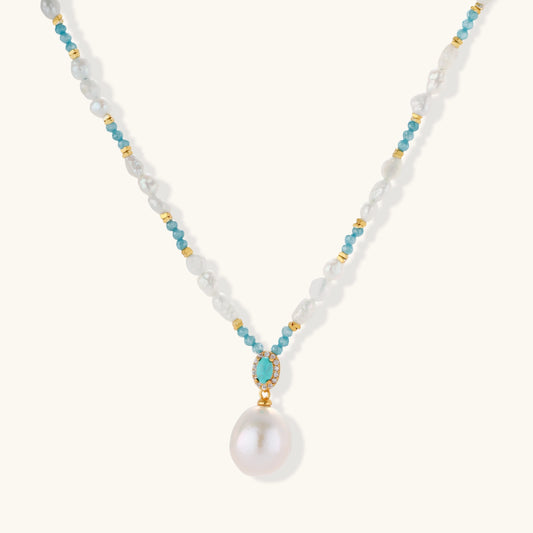 Beaded necklace with baroque pearls, turquoise stones, and gold accents featuring a large pearl pendant on white background.