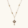 Y-shaped necklace with freshwater pearls, gold filigree stations, and ornate diamond-shaped centerpiece with pearl drop