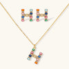Gold-plated letter H jewelry set with multicolor zirconia stones in emerald cuts, showing necklace pendant and matching earrings