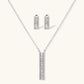 White gold plated necklace with vertical cubic zirconia pendant and matching hoop earrings on neutral background