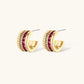 Three-piece jewelry set featuring 14K gold plated pieces with deep red cubic zirconia stones and clear crystals on cream background.
