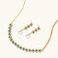 Gold-plated jewelry set with green cubic zirconia floral motifs, featuring matching necklace and pearl drop earrings
