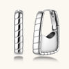 Close-up of platinum-plated sterling silver hoop earrings with horizontal textured grooves on white background.