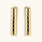 Chunky segmented gold-plated huggie hoop earrings with bamboo-inspired geometric design on white background.