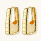 Chunky segmented gold-plated huggie hoop earrings with bamboo-inspired geometric design on white background.