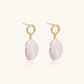 18K gold vermeil twisted circle studs with organic white baroque pearl drops on cream background