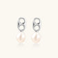 Modern rhodium-plated silver earrings with geometric double-circle design and freshwater pearl drops