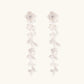 Long sterling silver drop earrings with delicate floral vine design and crystal accents on white background