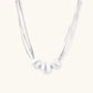 Sterling silver multi-strand necklace with three brushed round beads on cream background