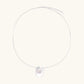 Sterling silver disc necklace with textured finish and centered freshwater pearl on delicate chain