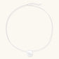 Minimalist brushed sterling silver dome pendant on delicate chain against cream background, showing matte textured finish