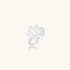 Sculptural sterling silver ring with organic branch design and textured surfaces on cream background