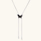 Dark wood butterfly earrings and necklace with silver chain accents on white background, showing natural grain texture.
