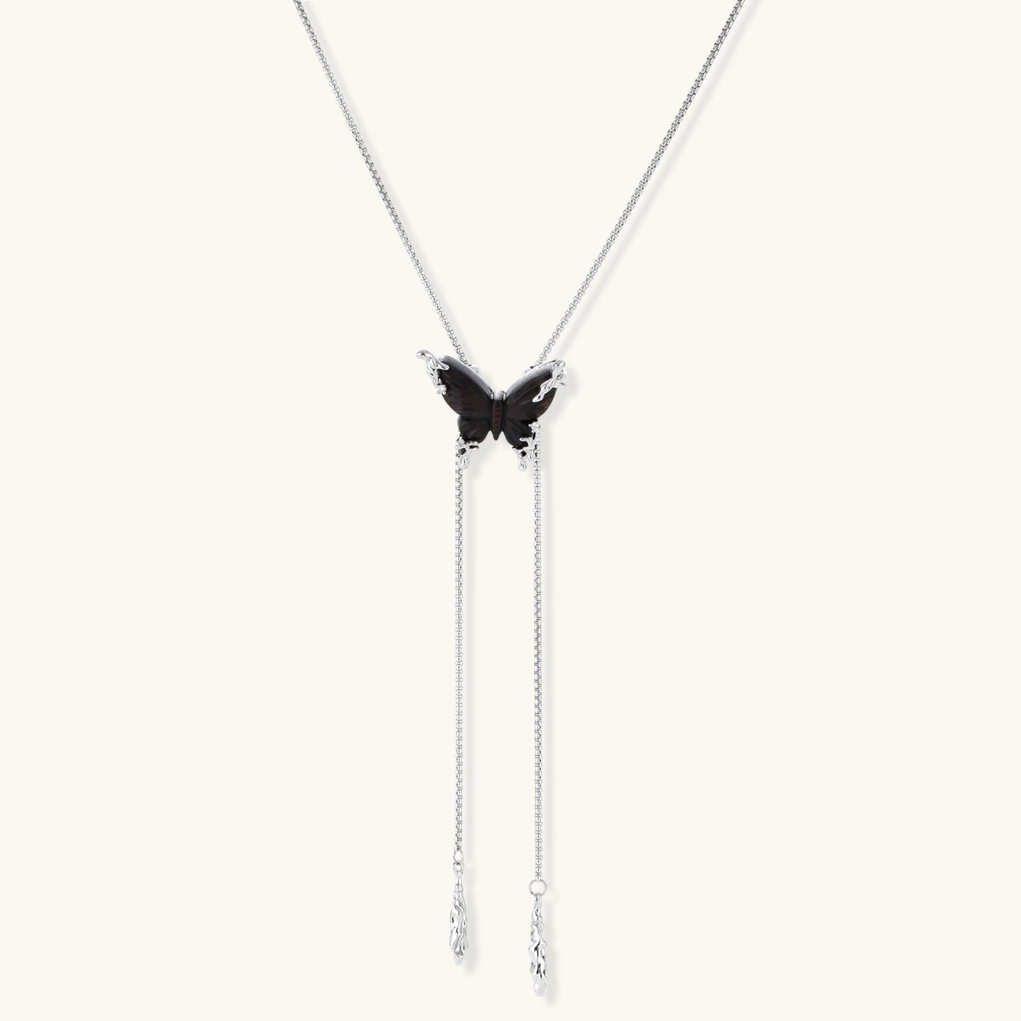 Dark wood butterfly earrings and necklace with silver chain accents on white background, showing natural grain texture.