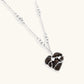 Dark ebony wood heart charms wrapped in intricate silver chains with crystal accents, shown as matching earrings and necklace set.