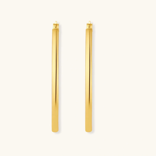 Set of geometric gold-plated sterling silver hoop earrings in oval and cushion shapes on cream background