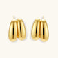 Chunky 18K gold-plated sterling silver hoop earrings with flowing sculptural curves on white background.