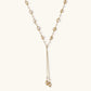 Adjustable gold lariat necklace with freshwater pearls nested in delicate cage settings and Y-shaped tassel drop