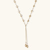 Adjustable gold lariat necklace with freshwater pearls nested in delicate cage settings and Y-shaped tassel drop