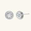 Close-up of sterling silver stud earrings featuring concentric circular frames with brilliant moissanite centers