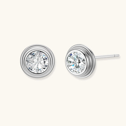 Close-up of sterling silver stud earrings featuring concentric circular frames with brilliant moissanite centers