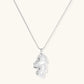 Modern sculptural pendant necklace with twisted metallic design on delicate silver chain against neutral background.