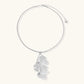 Modern sculptural pendant necklace with twisted metallic design on delicate silver chain against neutral background.