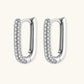 Close-up of platinum-plated sterling silver huggie hoops with pavé crystal setting on white background.