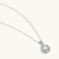 Platinum-plated sterling silver necklace with round halo pendant featuring central crystal surrounded by smaller stones