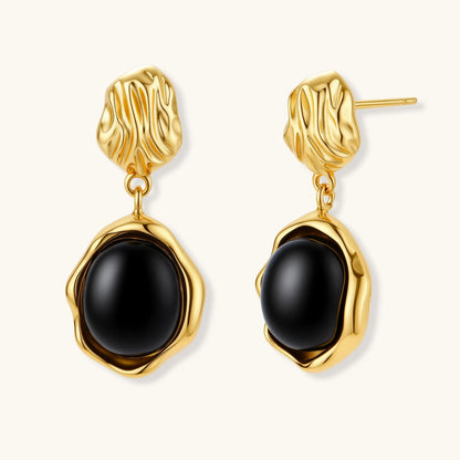 Gold-plated rippled stud earrings with black agate stone drops on white background