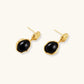 Gold-plated rippled stud earrings with black agate stone drops on white background