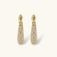 Gold-plated hoop earrings fully covered in sparkling zircon crystals with hinged closure on neutral background