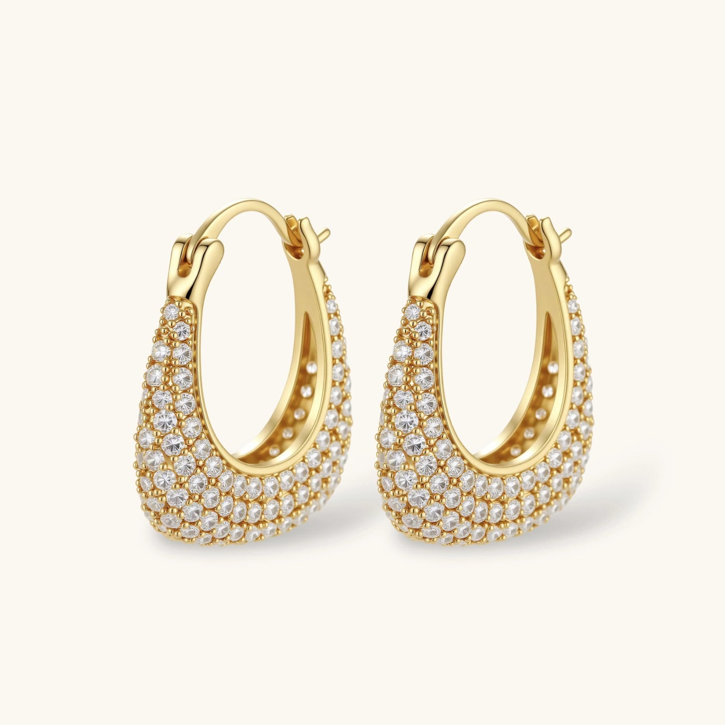 Gold-plated hoop earrings fully covered in sparkling zircon crystals with hinged closure on neutral background