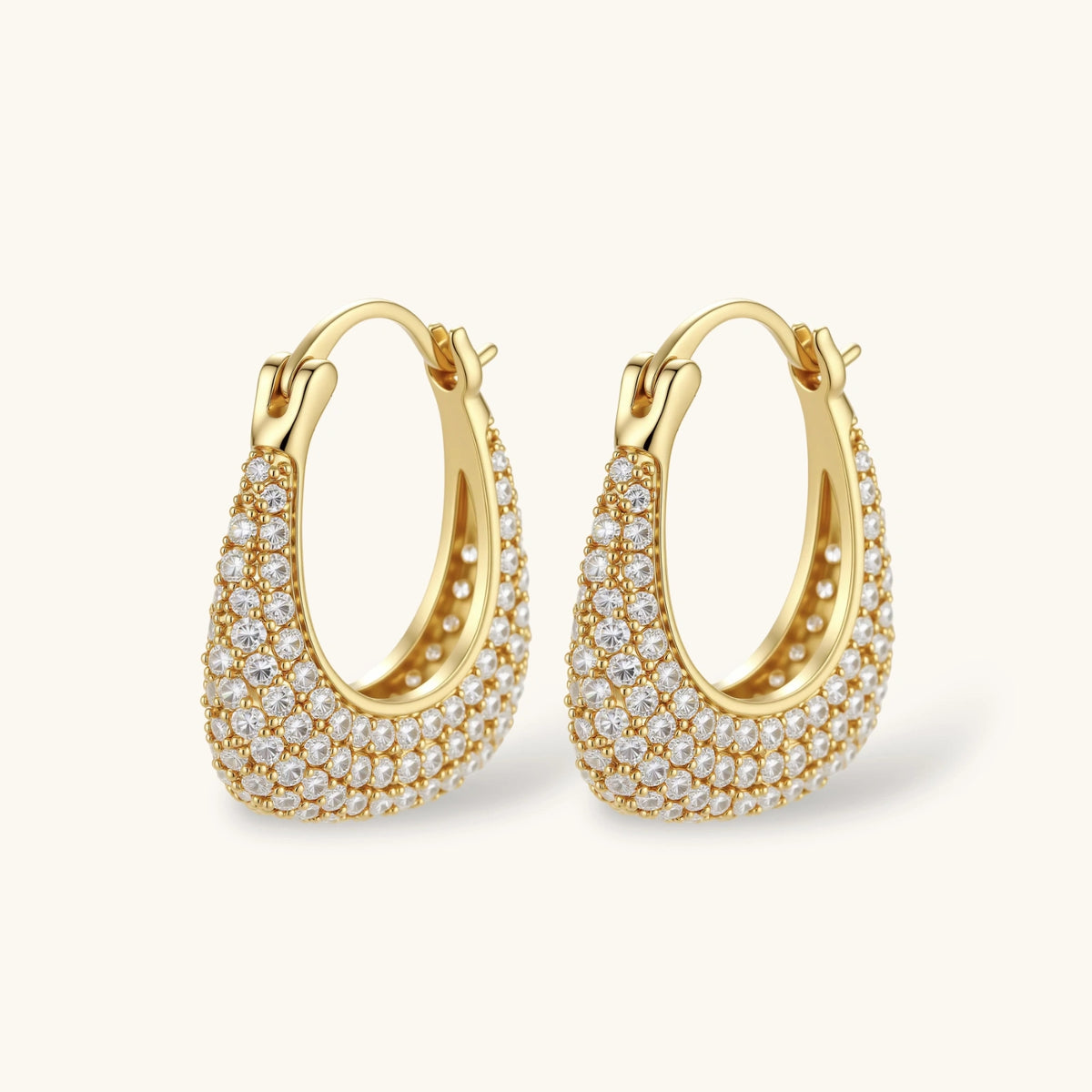 Gold-plated hoop earrings fully covered in sparkling zircon crystals with hinged closure on neutral background